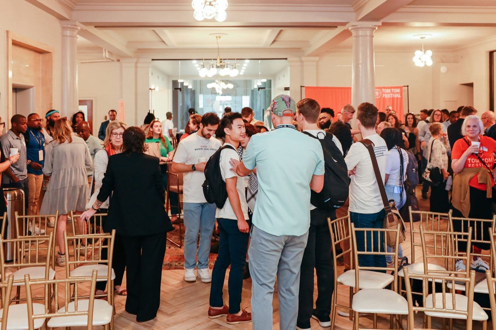 Community members mingling among gold chairs at a Commonwealth Justice Coalition gathering