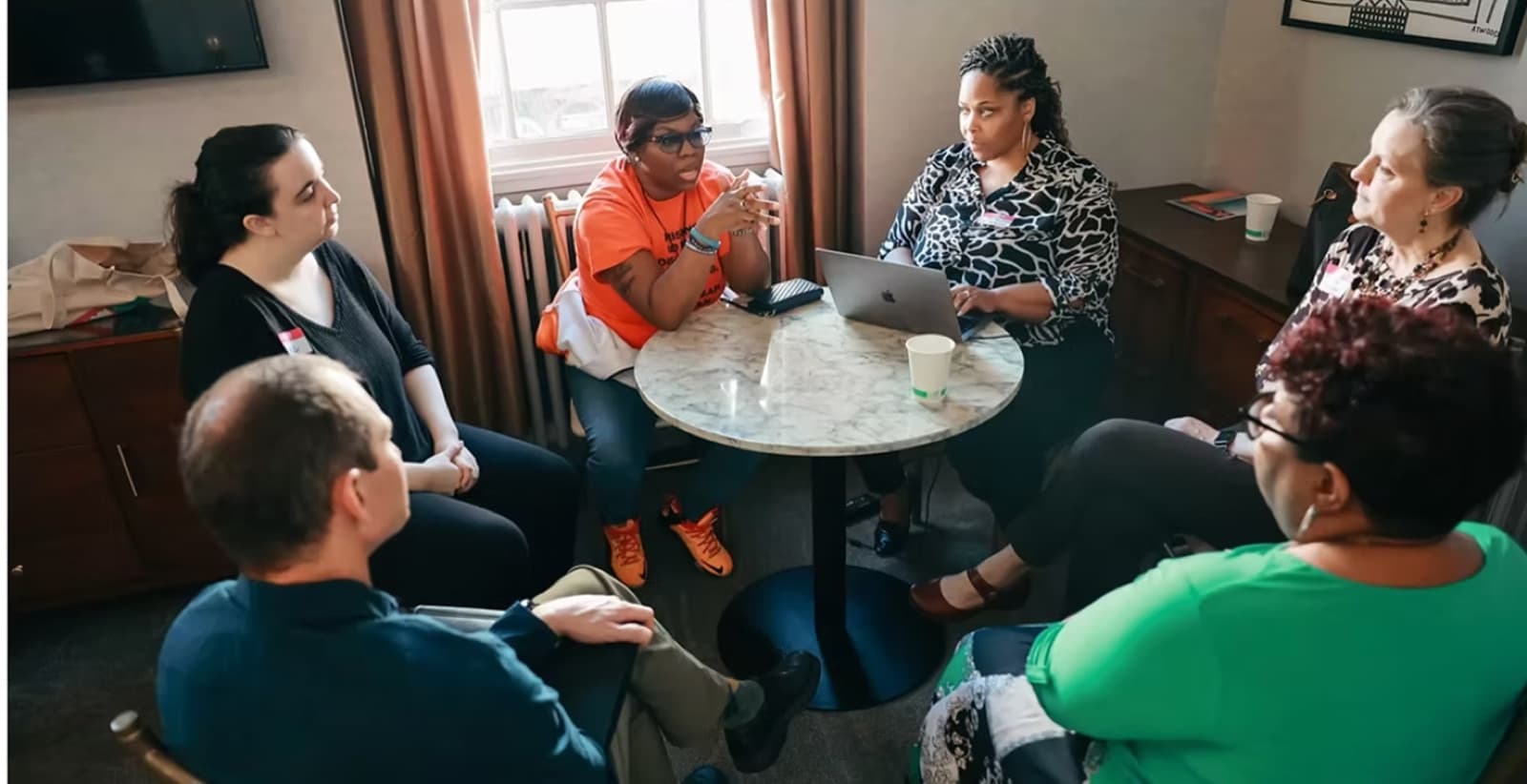 Justice leaders in a small-group discussion around a table